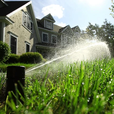 Sprinkler head irrigating a grassy lawn. Credit: wallpaperflare.com